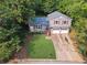 Split-level home with a two-car garage, driveway, front yard, and mature trees at 3919 Valley Brook Rd, Snellville, GA 30039