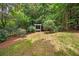 Picturesque backyard featuring lawn, trees, and a charming white pergola with swing at 8643 Ellard Dr, Alpharetta, GA 30022