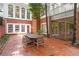 Brick patio with wooden table, surrounded by lush greenery and offering ample seating at 8643 Ellard Dr, Alpharetta, GA 30022