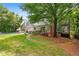 Landscaped backyard with pool, patio, walkway, and view of the home's exterior and porch at 8643 Ellard Dr, Alpharetta, GA 30022