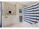 A charming bathroom featuring a white vanity, and a blue and white striped shower curtain at 8643 Ellard Dr, Alpharetta, GA 30022