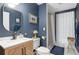 Stylish bathroom with blue walls, updated vanity, and a sleek glass shower at 8643 Ellard Dr, Alpharetta, GA 30022
