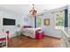 Bright bedroom featuring hardwood floors, two windows, and colorful decorations at 8643 Ellard Dr, Alpharetta, GA 30022