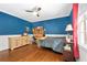 A well-lit bedroom featuring a ceiling fan, wooden floors, and tasteful decor at 8643 Ellard Dr, Alpharetta, GA 30022