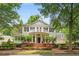 Charming two-story traditional home featuring a brick porch with columns and double-decker balconies nestled in a lush landscape at 8643 Ellard Dr, Alpharetta, GA 30022