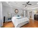 Spacious main bedroom with tray ceilings, wood floors, ensuite bathroom, and ceiling fan at 8643 Ellard Dr, Alpharetta, GA 30022