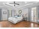 Spacious main bedroom with tray ceilings, wood floors, ensuite bathroom, and access to the balcony at 8643 Ellard Dr, Alpharetta, GA 30022