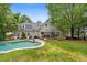 Backyard pool with stone trim, lawn, and views of the home's exterior, porch, and cupola at 8643 Ellard Dr, Alpharetta, GA 30022