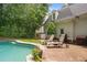 A backyard featuring a pool, lounge chairs, and lush landscaping at 8643 Ellard Dr, Alpharetta, GA 30022