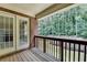 View of the wooden back porch features a brick wall with a nice wooded view at 1102 Lexington Dr, Roswell, GA 30075