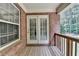View of the wooden back porch features a brick wall with a nice wooded view at 1102 Lexington Dr, Roswell, GA 30075