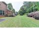 View of the backyard featuring green grass, nice landscaping, and tall trees at 1102 Lexington Dr, Roswell, GA 30075