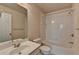 This bright bathroom has a shower-tub combo with tiled walls, toilet, vanity, and a large mirror at 1102 Lexington Dr, Roswell, GA 30075