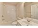 A well-lit bathroom includes a tub with tiled walls, a vanity, and a large mirror at 1102 Lexington Dr, Roswell, GA 30075