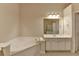 Bathroom featuring a soaking tub, double sink vanity, and tile flooring at 1102 Lexington Dr, Roswell, GA 30075