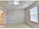 A bright bedroom has a ceiling fan and window with blinds, complete with neutral carpet and wall paint at 1102 Lexington Dr, Roswell, GA 30075