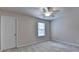 A neutral bedroom features carpet, a window with blinds, a ceiling fan, and a closet door at 1102 Lexington Dr, Roswell, GA 30075