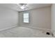 Empty bedroom featuring neutral walls and carpet, with a ceiling fan and a window at 1102 Lexington Dr, Roswell, GA 30075