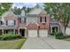 Charming brick townhome featuring an attached two-car garage and a well-manicured lawn at 1102 Lexington Dr, Roswell, GA 30075