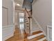 Bright hallway with hardwood floors, white trim, and a staircase leading upstairs at 1102 Lexington Dr, Roswell, GA 30075