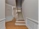 Hallway with hardwood floors, classic white trim, and a staircase leading upstairs at 1102 Lexington Dr, Roswell, GA 30075