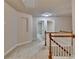 Carpeted second story hallway with white banister, natural light, and multiple doorways at 1102 Lexington Dr, Roswell, GA 30075