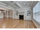 Elegant living room with a fireplace, built-in bookshelves, and hardwood floors and large windows at 1102 Lexington Dr, Roswell, GA 30075