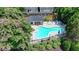Aerial view of a community pool with lounge chairs and tables surrounded by greenery at 1102 Lexington Dr, Roswell, GA 30075