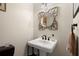 Elegant powder room with decorative mirror and stylish pedestal sink at 3330 Overland Dr, Roswell, GA 30075