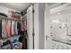 View of an organized walk-in closet with hanging clothes and the doorway to a modern white marble shower room at 3330 Overland Dr, Roswell, GA 30075