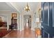Elegant entryway featuring hardwood floors, neutral paint, beautiful chandelier, and antique furniture at 3330 Overland Dr, Roswell, GA 30075