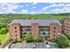 Beautiful building with a brick facade, balconies, and well-maintained landscaping in a wooded area at 3330 Overland Dr, Roswell, GA 30075