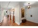 Hallway featuring hardwood floors, art display, a decorative chandelier, and an archway that leads to a balcony at 3330 Overland Dr, Roswell, GA 30075
