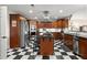 Gourmet kitchen with stainless appliances, custom wood cabinets, cooktop island, checkerboard floors, and modern lighting at 3330 Overland Dr, Roswell, GA 30075