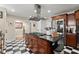 A chef's kitchen featuring an island with gas range, modern vent hood, stainless steel fridge, and checkerboard flooring at 3330 Overland Dr, Roswell, GA 30075
