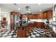 Open concept kitchen with stainless steel appliances, cherry wood cabinets, center island with cooktop, and checkerboard floors at 3330 Overland Dr, Roswell, GA 30075
