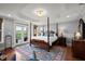 Spacious main bedroom with a four-poster bed and access to a private balcony at 3330 Overland Dr, Roswell, GA 30075