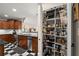 Pantry with organized shelving next to kitchen featuring stainless steel appliances, wood cabinets and checkerboard flooring at 3330 Overland Dr, Roswell, GA 30075