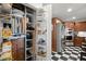 A kitchen pantry featuring pull-out shelving next to a stainless-steel refrigerator and black and white checkered flooring at 3330 Overland Dr, Roswell, GA 30075