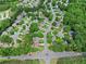 Aerial shot of a neighborhood with tree-lined streets and well-maintained homes next to a green area at 530 Camber Woods Dr, Roswell, GA 30076
