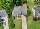 Aerial view of a well-maintained home with lush green lawns, mature trees, and a long driveway at 530 Camber Woods Dr, Roswell, GA 30076