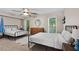 Bedroom with two beds, ceiling fan, and windows offering natural light and outdoor views at 530 Camber Woods Dr, Roswell, GA 30076