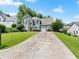 Two-story home with manicured lawn and three-car garage and a long driveway in a suburban neighborhood at 530 Camber Woods Dr, Roswell, GA 30076