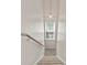 A carpeted staircase with wooden handrail and pendant lighting leads to the next level at 530 Camber Woods Dr, Roswell, GA 30076