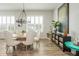 Bright dining room features wood floors, decorative chandelier, and natural light at 6895 Whitman Walk, Alpharetta, GA 30005
