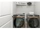 Modern laundry room featuring a Samsung washer and dryer and convenient overhead shelving for ample storage at 6895 Whitman Walk, Alpharetta, GA 30005
