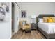 Bedroom featuring a comfortable bed with a yellow accent pillows, a nightstand, and a stylish arm chair at 6895 Whitman Walk, Alpharetta, GA 30005