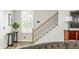 Elegant staircase with wood and iron railings, with natural light from a large window at 6895 Whitman Walk, Alpharetta, GA 30005