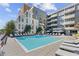 Relaxing community pool with lounge chairs, umbrellas, and modern building architecture at 775 Juniper St # 111, Atlanta, GA 30308