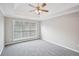 Bedroom with plush carpet, a ceiling fan, and a large window for natural light at 1147 Saint Phillips Ct, Locust Grove, GA 30248